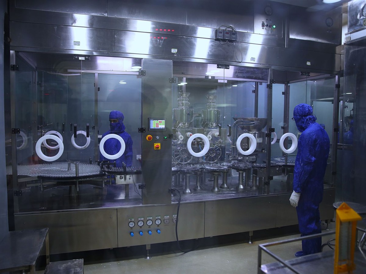 Cleanroom filling line with technicians in protective suits